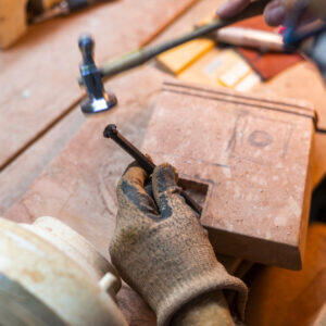 Artigiano al lavoro su casetta in trachite sarda