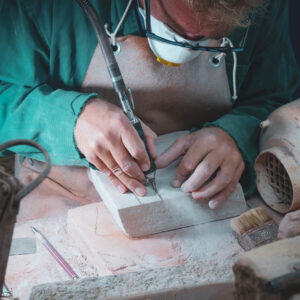 Artigiano al lavoro su casetta in trachite sarda